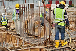 Group of construction workers fabricating ground beam formwork